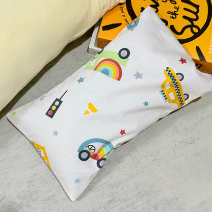 Husk pillow with colorful car, rainbow, and star designs on a gray surface.