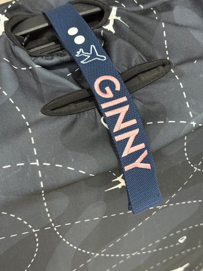 Navy luggage strap with 'GINNY' text on a luggage