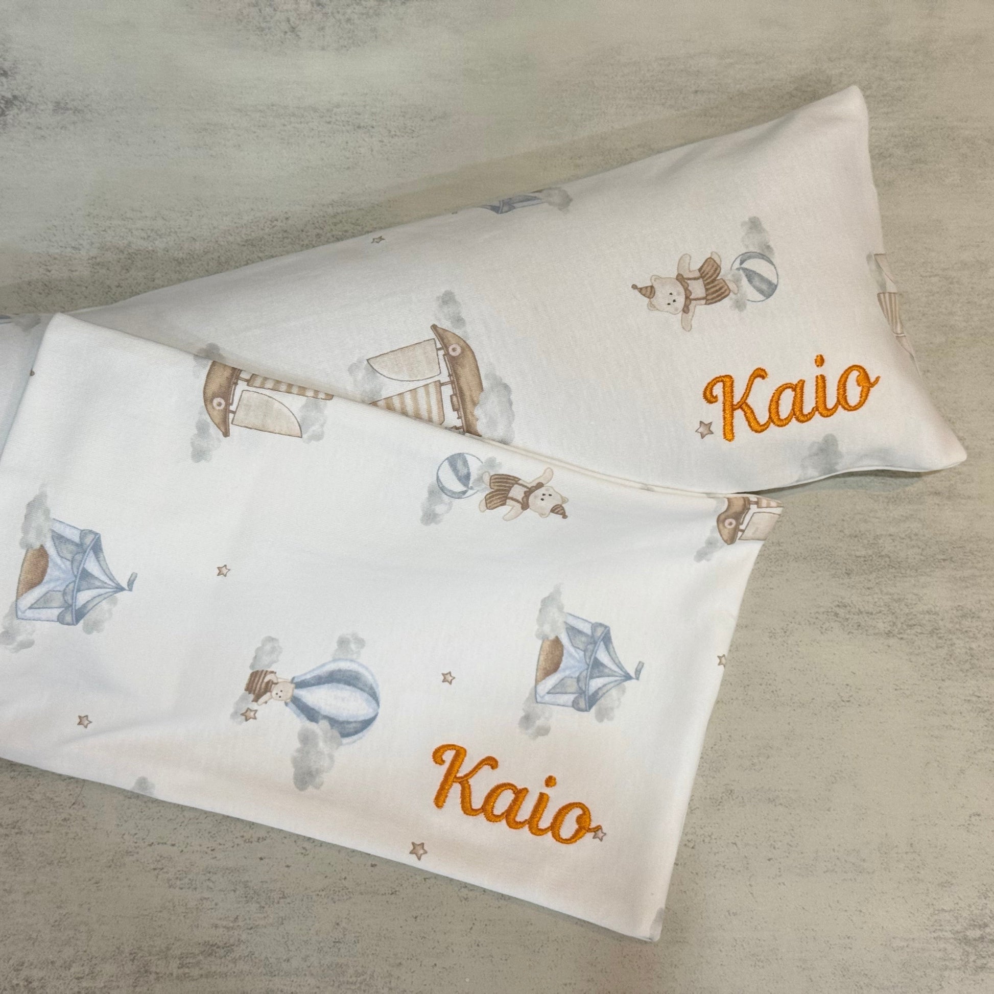 Two pillowcases with sailboat pattern and 'Kaio' branding on a textured surface