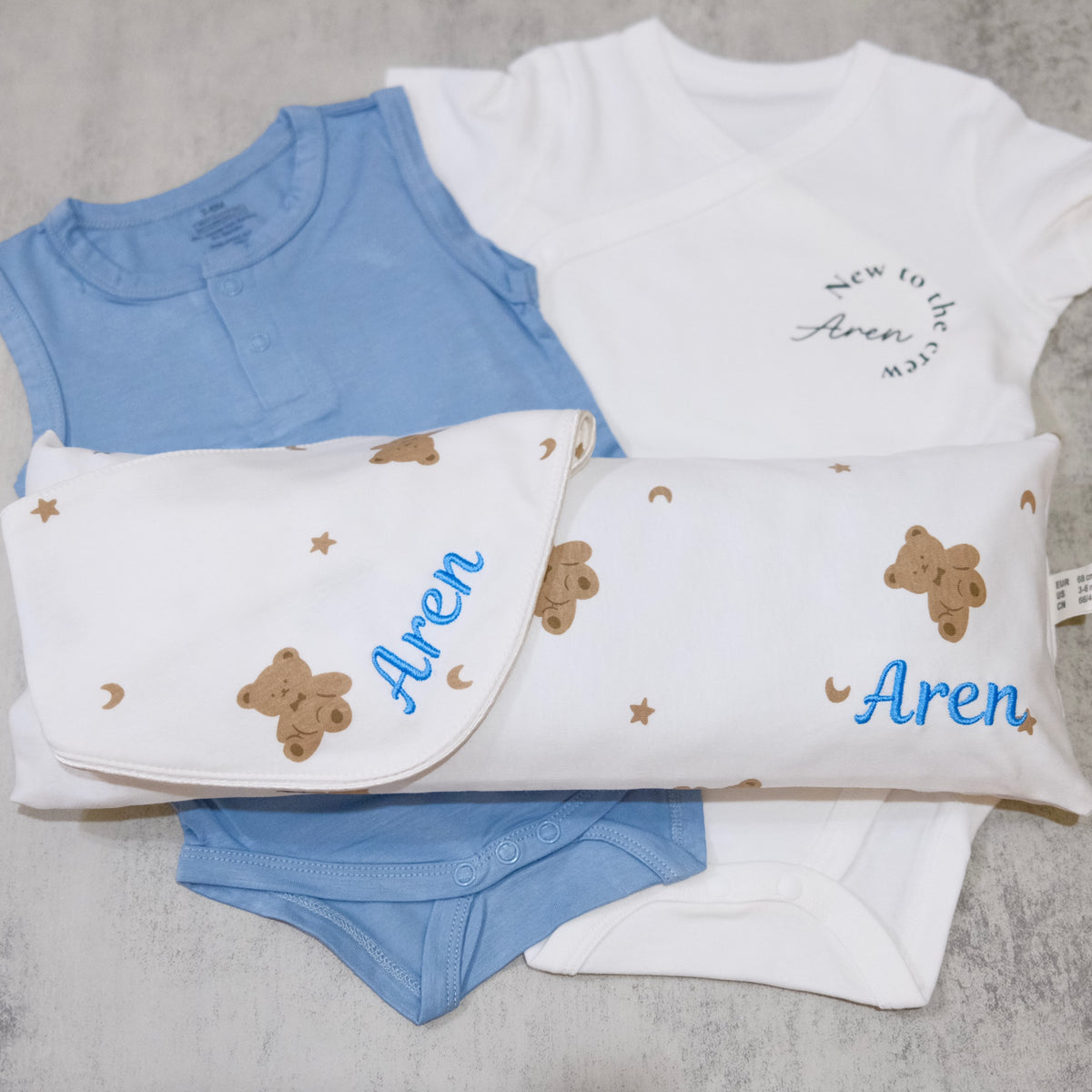 Personalised gift set with husk pillow, bib, romper and bodysuit embroidered with Aren