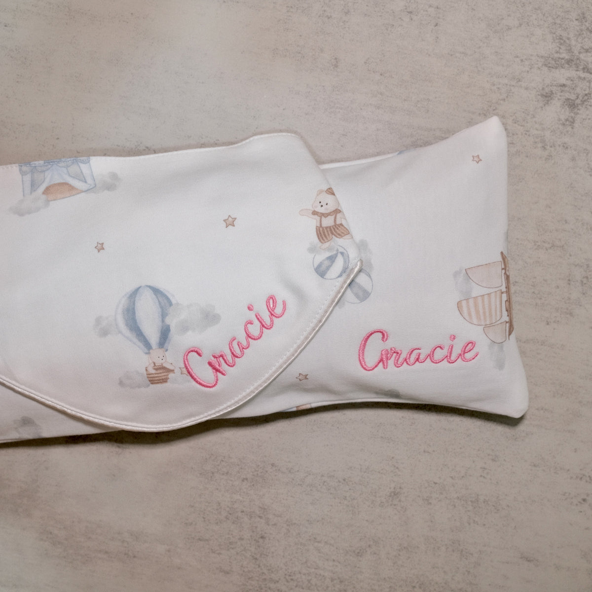 Hot air balloon print pillow and bib embroidered with Gracie in pink